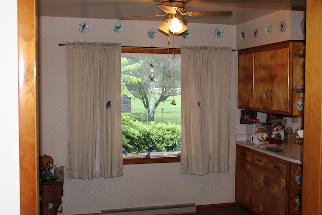 6 Woodside Dr, Arcanum, OH 45304 - kitchen featuring wallpapered walls, baseboard heating, a ceiling fan, brown cabinets, and light countertops