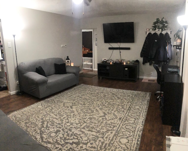 living area featuring ceiling fan, baseboards, and wood finished floors