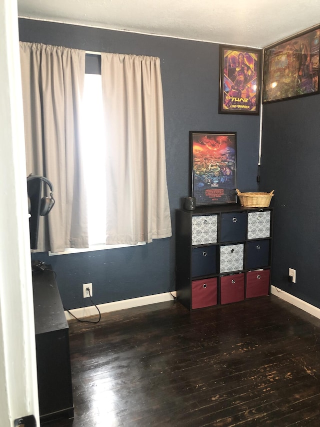 bedroom featuring wood finished floors and baseboards