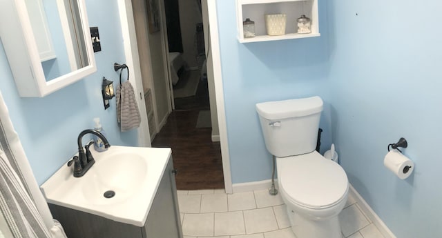 bathroom with baseboards, vanity, toilet, and tile patterned floors