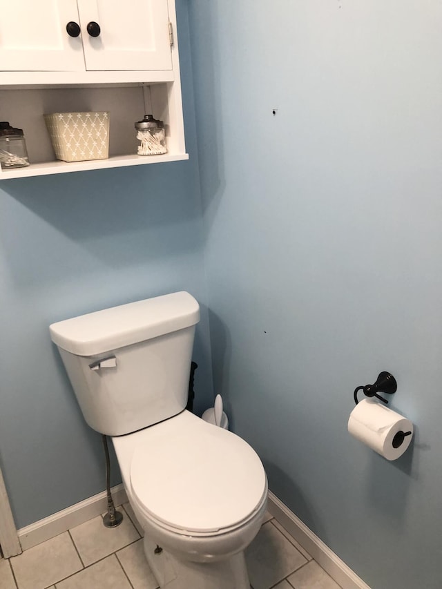 bathroom featuring toilet, tile patterned flooring, and baseboards