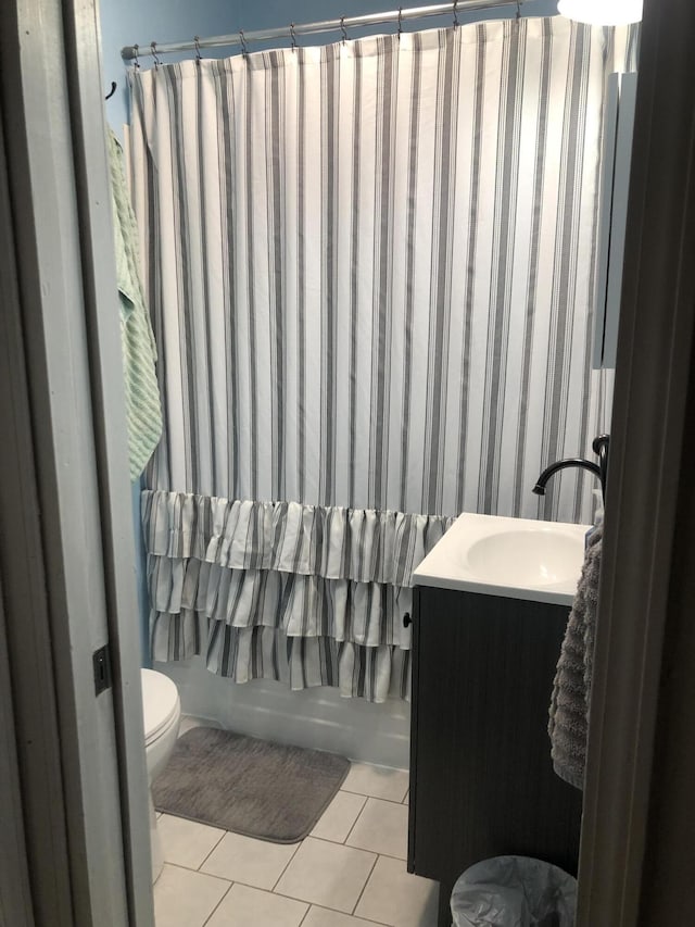 bathroom featuring toilet, vanity, shower / bath combo with shower curtain, and tile patterned floors