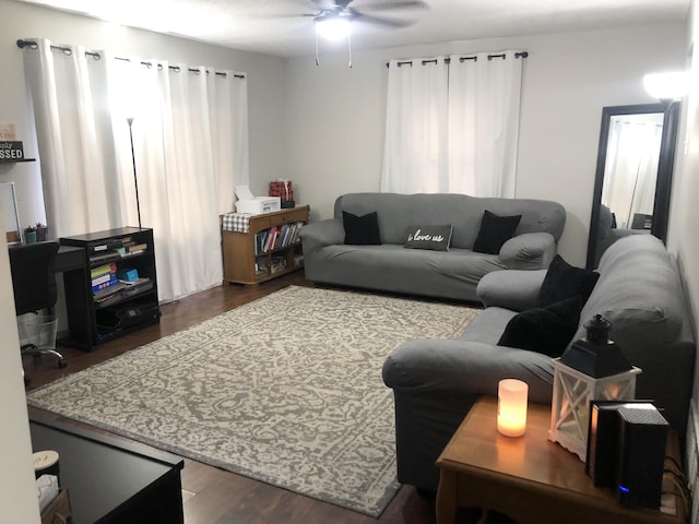 living room with ceiling fan and dark wood-type flooring