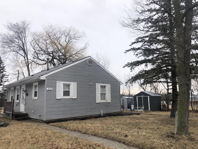 view of side of home with an outdoor structure, a lawn, and a shed