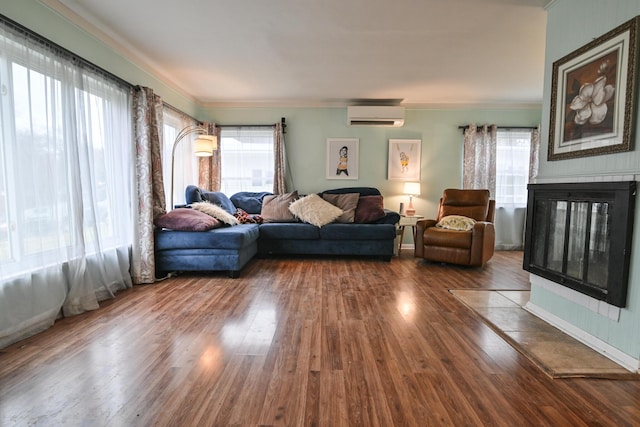 living room with hardwood / wood-style flooring, a multi sided fireplace, ornamental molding, and a wall mounted AC