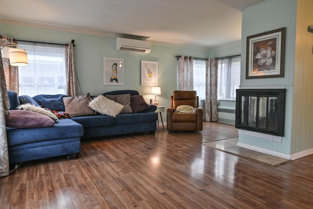 living room featuring radiator heating unit, dark hardwood / wood-style floors, a wall mounted AC, and a wealth of natural light