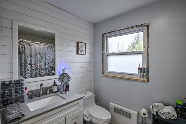 bathroom with radiator heating unit, toilet, a shower with shower curtain, and vanity