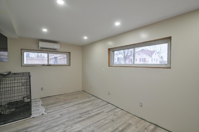 interior space with a wall mounted AC and light wood-type flooring