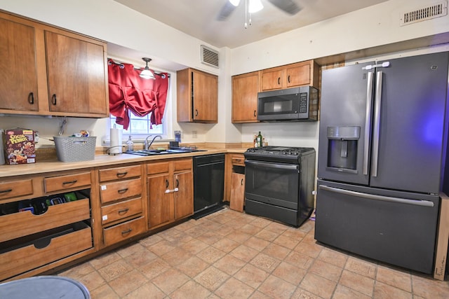 kitchen with sink, stainless steel fridge, ceiling fan, black dishwasher, and gas range oven