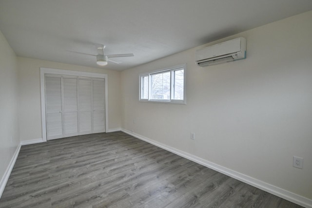 unfurnished bedroom featuring ceiling fan, a wall mounted AC, light hardwood / wood-style floors, and a closet