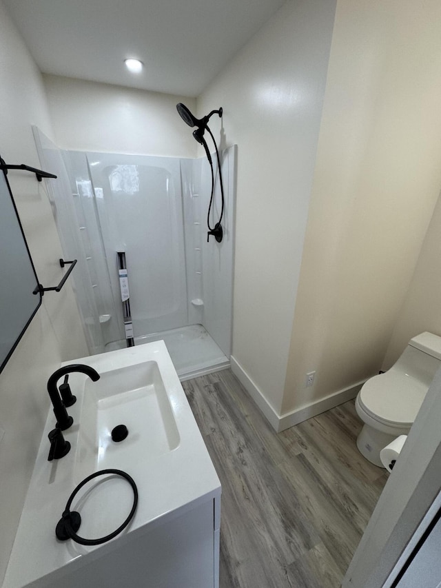 bathroom featuring wood-type flooring, toilet, and walk in shower