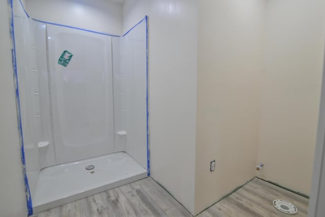 bathroom featuring hardwood / wood-style flooring and walk in shower