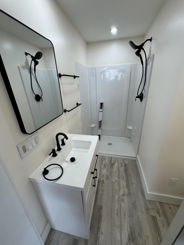 bathroom featuring vanity, hardwood / wood-style floors, and walk in shower