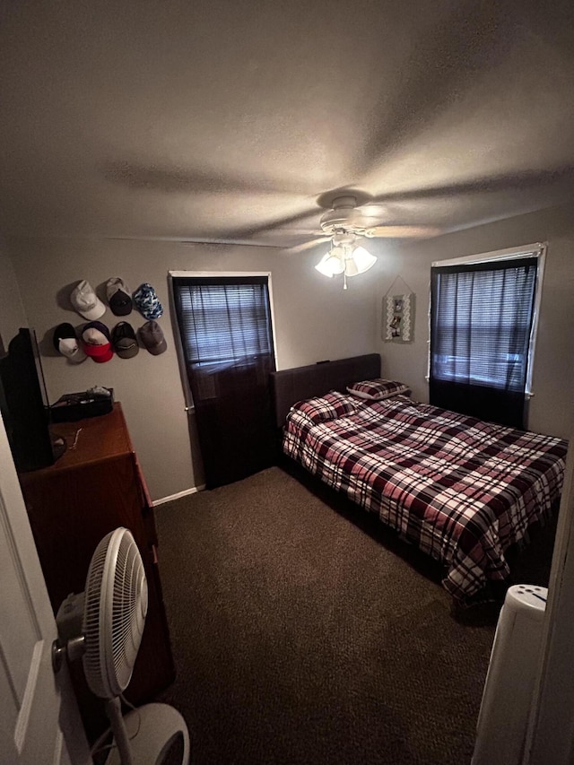 bedroom with a textured ceiling, carpet, and a ceiling fan