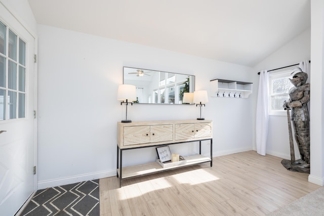 interior space with lofted ceiling, wood finished floors, and baseboards