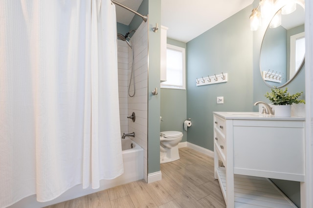 full bathroom with baseboards, toilet, shower / bath combo, wood finished floors, and vanity