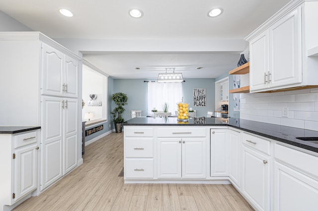 kitchen with dark countertops, white cabinets, a peninsula, and open shelves