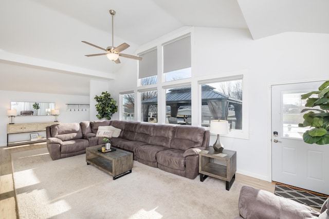 living area featuring high vaulted ceiling, a ceiling fan, baseboards, and wood finished floors