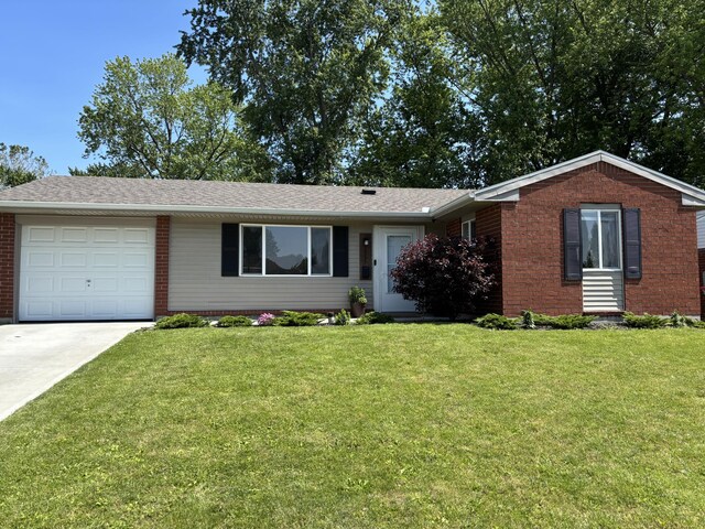 1353 Lee Rd, Troy, OH 45373 - single story home with an attached garage, concrete driveway, brick siding, and a front yard