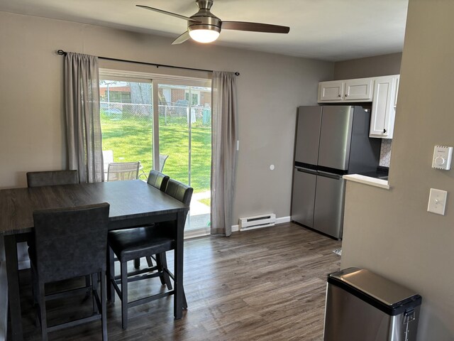 1353 Lee Rd, Troy, OH 45373 - dining space featuring baseboard heating, ceiling fan, dark wood-type flooring, and baseboards