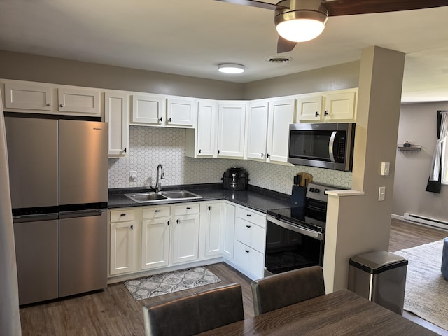 1353 Lee Rd, Troy, OH 45373 - kitchen with appliances with stainless steel finishes, a sink, dark countertops, tasteful backsplash, and dark wood-type flooring