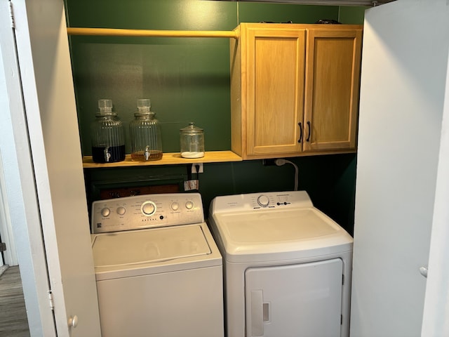 1353 Lee Rd, Troy, OH 45373 - laundry area with cabinet space, washing machine and clothes dryer, and wood finished floors