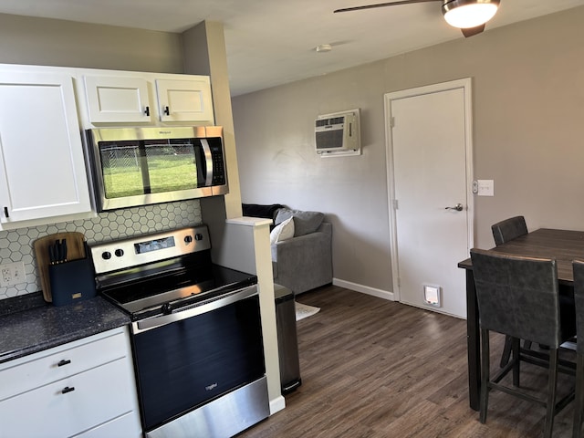 1353 Lee Rd, Troy, OH 45373 - kitchen featuring stainless steel appliances, dark wood finished floors, decorative backsplash, white cabinetry, and dark countertops
