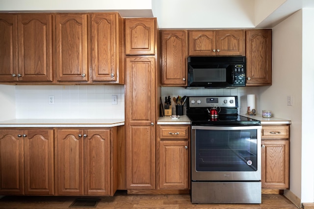 1706 N Fountain Blvd, Springfield, OH 45504 - kitchen with stainless steel range with electric stovetop, black microwave, tasteful backsplash, and light countertops