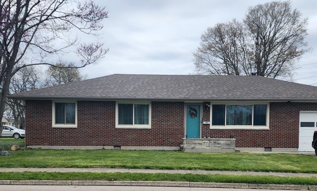 ranch-style home featuring a shingled roof, a front lawn, and brick siding