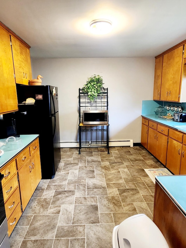 kitchen featuring brown cabinets, stainless steel microwave, and baseboards