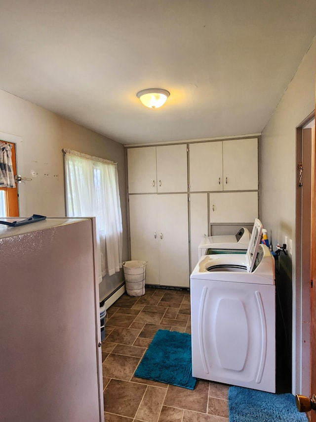 laundry room featuring cabinet space, a baseboard heating unit, and washing machine and clothes dryer