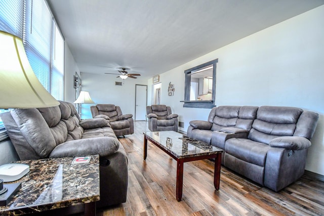 living area with wood finished floors and a ceiling fan