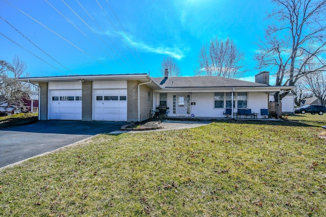 single story home featuring an attached garage, brick siding, driveway, a chimney, and a front yard