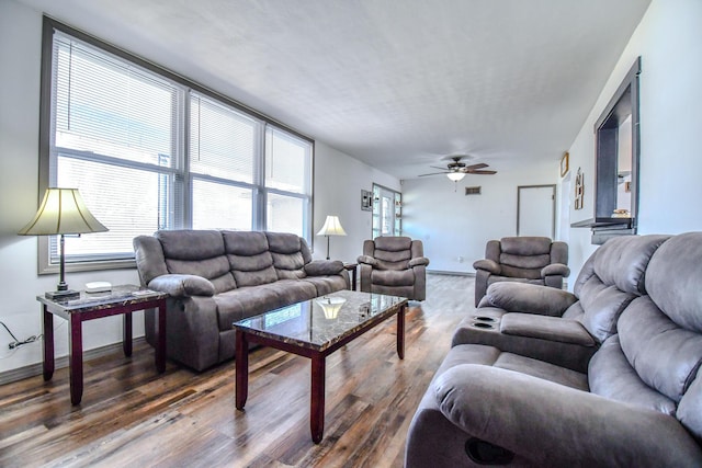 living room with ceiling fan, wood finished floors, visible vents, and baseboards