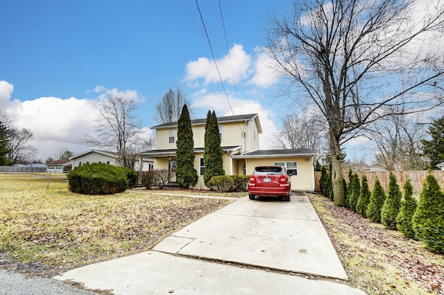 traditional-style house with a front yard and fence