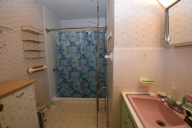 718 Center Ave, Russells Point, OH 43348 - bathroom featuring tile patterned floors, tiled shower, vanity, wallpapered walls, and wainscoting