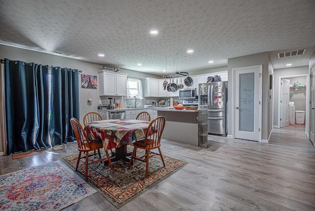 1313 Arrowhead, Piqua, OH 45356 - dining room with light wood finished floors, a textured ceiling, and recessed lighting