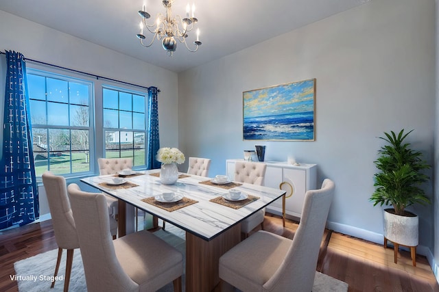 dining room with baseboards, wood finished floors, and an inviting chandelier