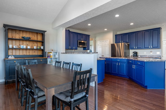 dining room with recessed lighting, lofted ceiling, dark wood-type flooring, a textured ceiling, and baseboards