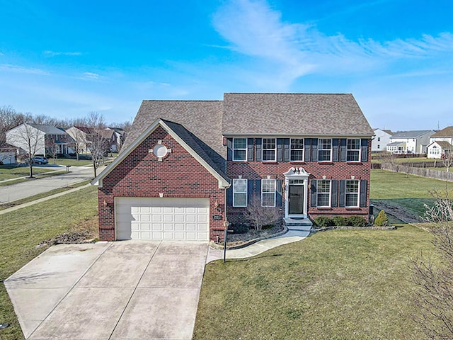 colonial-style house with a garage, a front lawn, a residential view, and brick siding