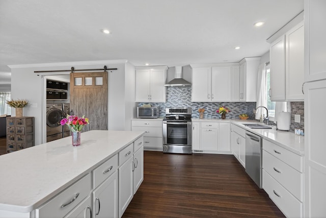1814 Kingsbury Dr, Saint Marys, OH 45885 - kitchen featuring appliances with stainless steel finishes, wall chimney exhaust hood, washer and dryer, tasteful backsplash, and white cabinetry