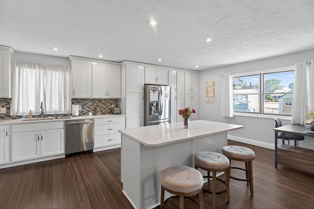 1814 Kingsbury Dr, Saint Marys, OH 45885 - kitchen with appliances with stainless steel finishes, backsplash, dark wood-style floors, a breakfast bar, and recessed lighting
