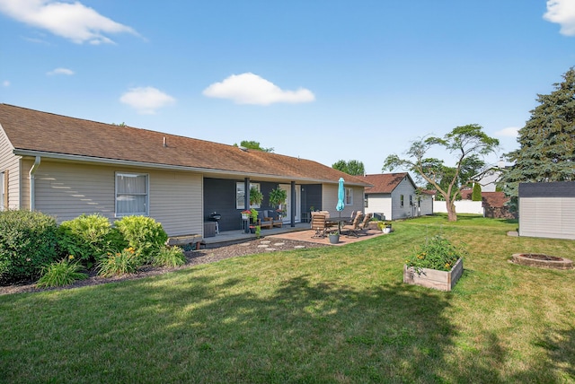 1814 Kingsbury Dr, Saint Marys, OH 45885 - rear view of house featuring a fire pit, a yard, a patio area, and a shingled roof