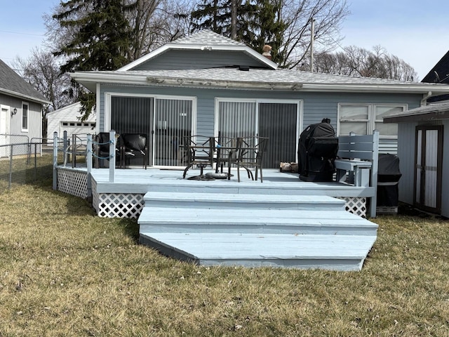 back of house featuring a lawn, fence, and a wooden deck