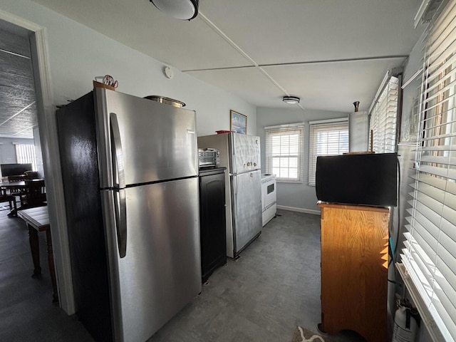 kitchen with white range with electric stovetop, vaulted ceiling, and freestanding refrigerator