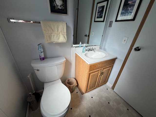 half bathroom with tile patterned floors, toilet, and vanity