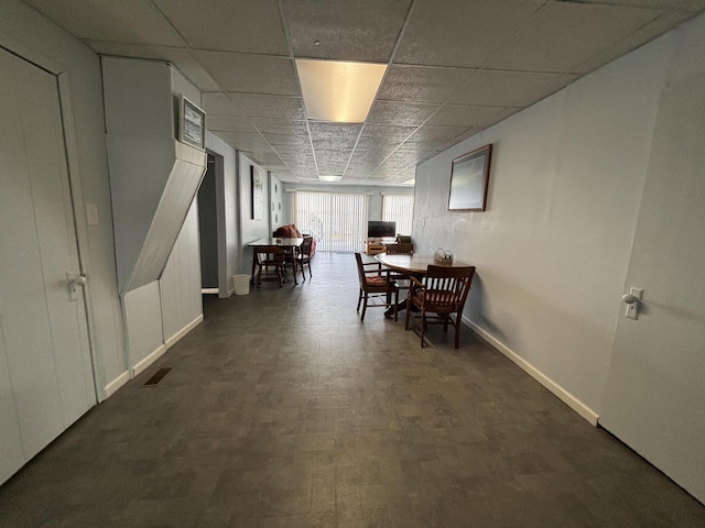 dining room featuring visible vents, a paneled ceiling, baseboards, and wood finished floors