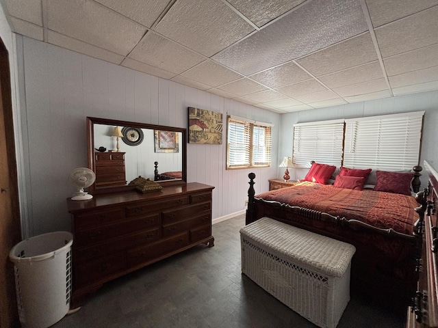 bedroom with wood finished floors and a drop ceiling