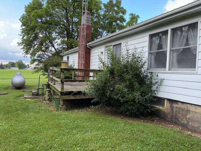 9050 N State Route 49, Greenville, OH 45331 - view of home's exterior featuring a wooden deck, a lawn, and a chimney