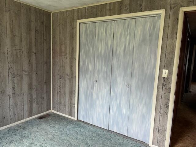 9050 N State Route 49, Greenville, OH 45331 - unfurnished bedroom featuring a closet, wood walls, and carpet flooring